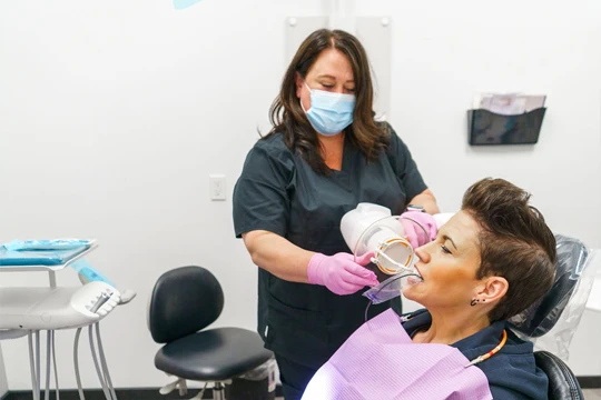 Dental assistant preparing patient for X-Rays in dental chair